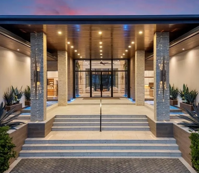The illuminated entrance to a Gregory Pascale home at dusk